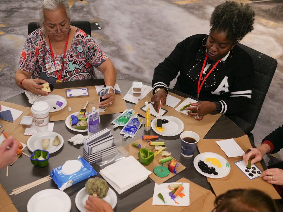 EFNEP educators practicing an actiivity using produce as a stamp to make art 