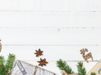 Wooden reindeer, wrapped gifts and pine sprigs on white wood background; NC Cooperative Extension