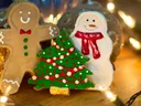 Gingerbread man, decorated tree, and snowman cookies with string lights; NC Cooperative Extension logo