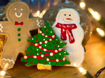 Gingerbread man, decorated tree, and snowman cookies with string lights; NC Cooperative Extension logo