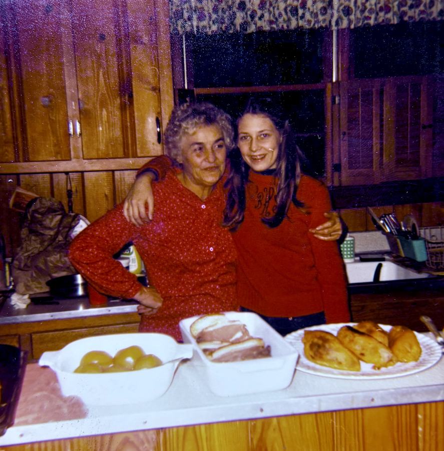 Inez in the kitchen with my mom around a table of food.