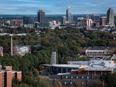 An aerial photo of the Talley Student union with the downtown Raleigh skyline in the background.
