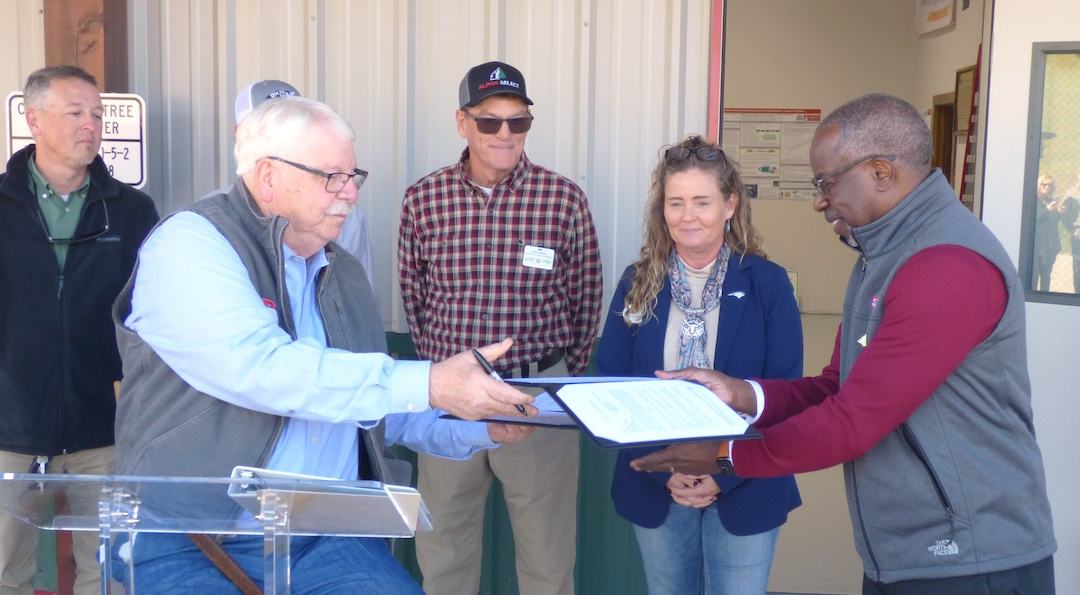 Steve Troxler and Dr. Myron Floyd sign licensing agreement.