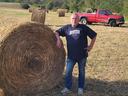 Field with hay equipment and round hay bales