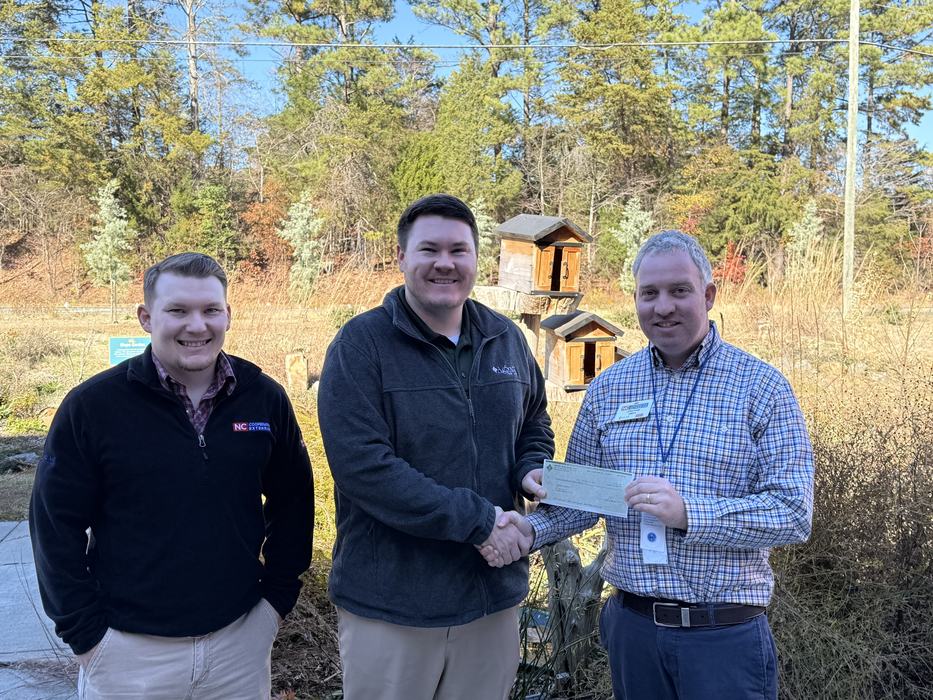 AgSouth Loan Officer John Michael Scott presents Growing Our Communities grant check to County Extension Director Jonathon Smith and Livestock Agent Alex Kissinger on November 17 in Hillsborough.  