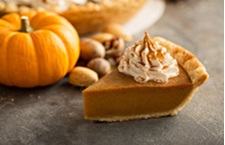 Pumpkin pie slice with whipped cream topping.