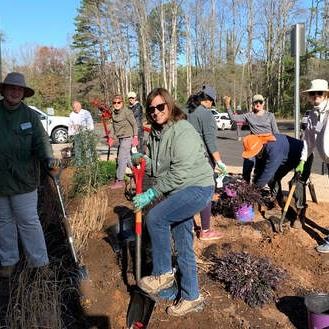 Image focused on adult woman standing one foot on a shovel.