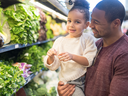 Father holding daughter near produce aisle; text "Produce in Season"