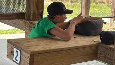 Person at shooting bench aiming a rifle from lane 2