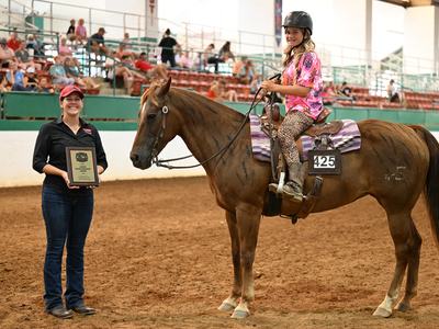 Young rider on horse #425 receiving a plaque reading 'Junior Sportsmanship Award'