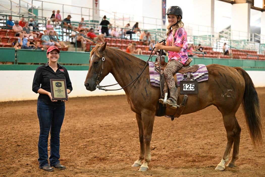 Young rider on horse #425 receiving a plaque reading 'Junior Sportsmanship Award'