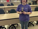 Image of Meredith Byers standing in kitchen holding her golden star award