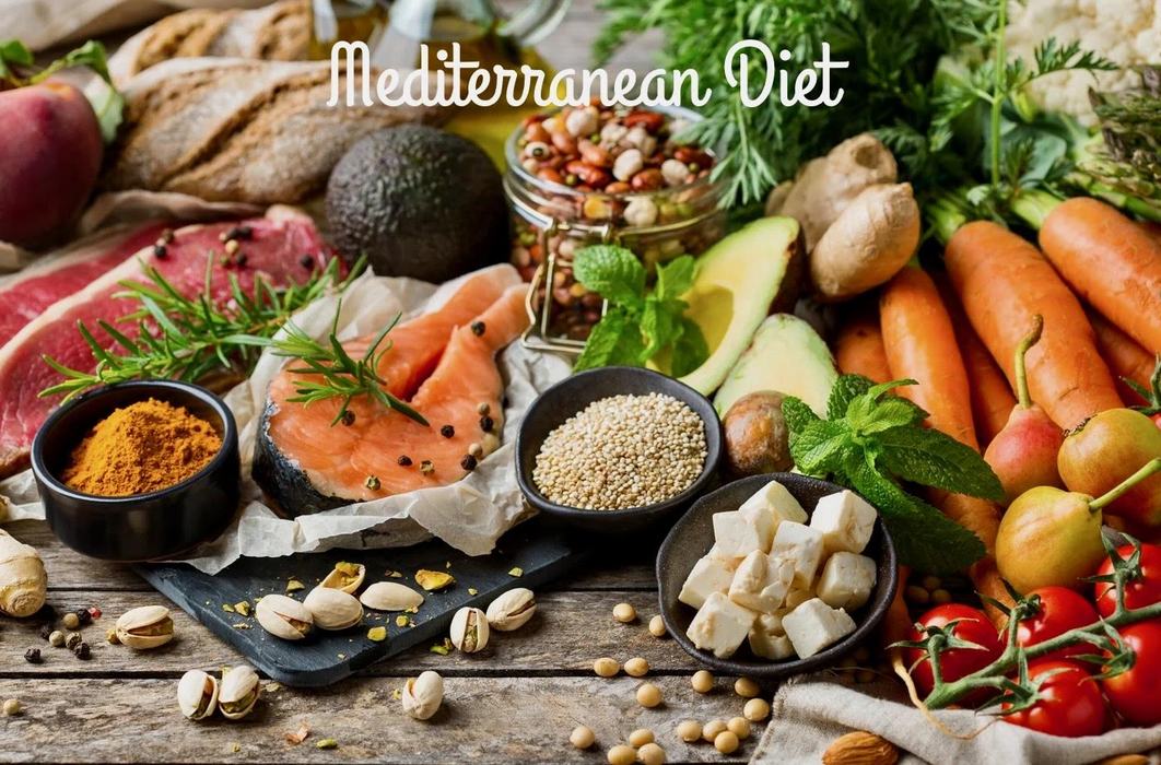 Mediterranean Diet text over assorted foods: salmon, avocado, carrots, tomatoes, feta
