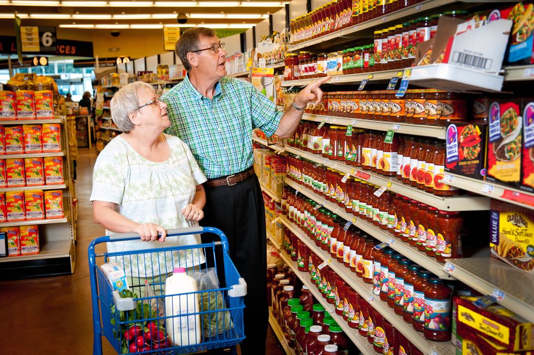 Photo of an elderly man and woman shopping for groceries. 