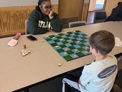 Youth and teen playing checkers the colonial way