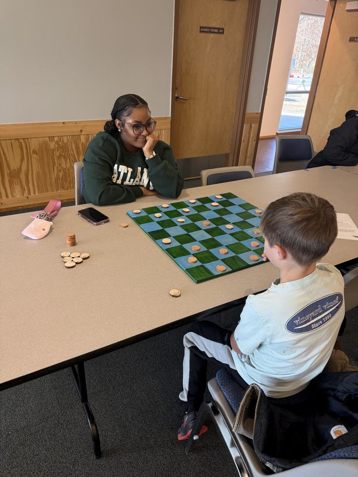 Youth and teen playing checkers the colonial way