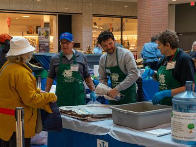 EMG volunteers wrapping tree seedlings for TreeFest participant