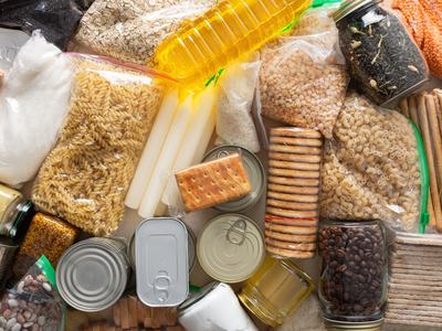 Assorted nonperishable food items: pasta, rice, lentils, canned goods, crackers, oil, beans