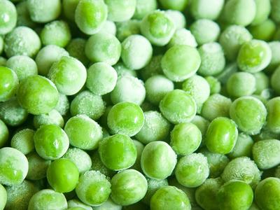 Frozen green peas with ice crystals on their surfaces