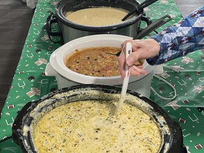 table with crockpots full of soup