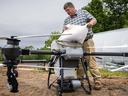 David Davis, director of Extension's Yancey County Center, loads grass seed into an agricultural drone.