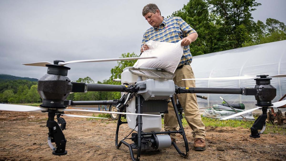 Yancey County Extension director David Davis loads grass seed into an agricultural drone