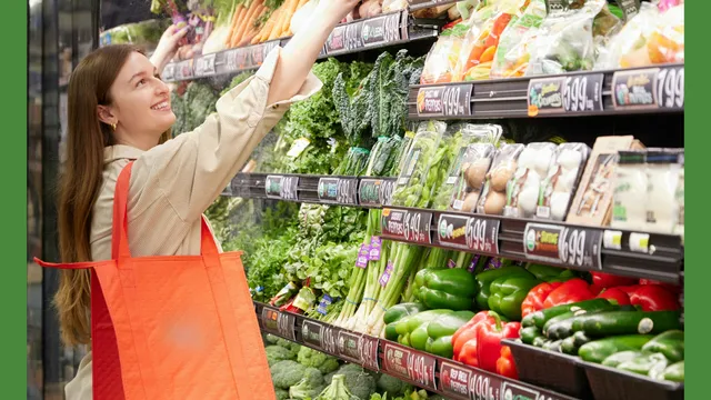Young adult female reaching for an item in the produce section of the grocery store