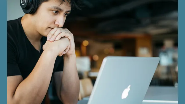 A man sitting at a desk working on a laptop.