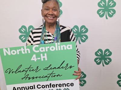 photo of woman holding a 4-H sign