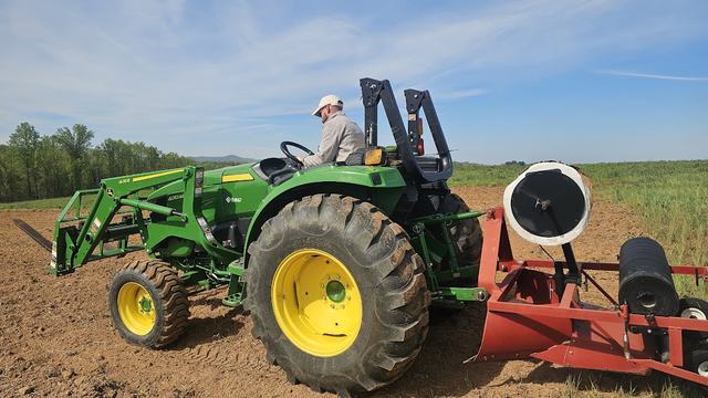 A tractor hooked up to a plastic layer