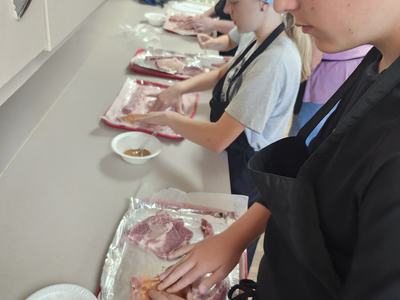 Youth layout their pork chops on trays as they begin to add their seasoning blends.