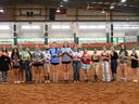 Several of the 2026 Achievement Award winners are posing with their prizes in the main arena of the Hunt Horse Complex.