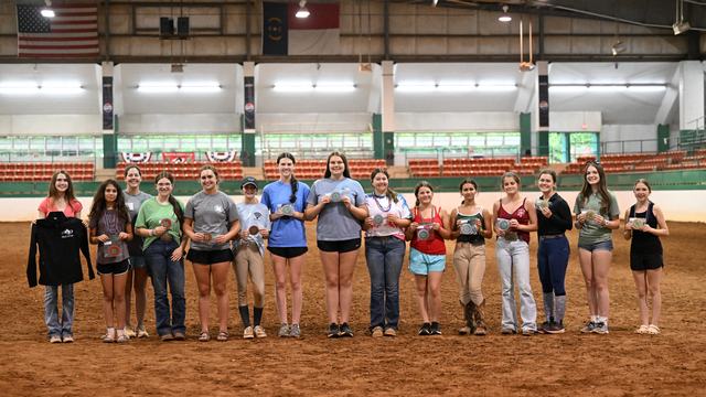 Several of the 2026 Achievement Award winners are posing with their prizes in the main arena of the Hunt Horse Complex.