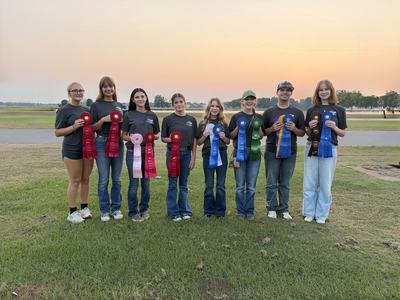 A team of youth holding ribbons after winning a competition.
