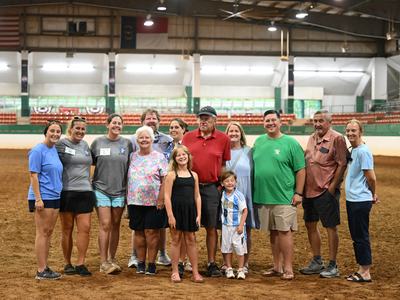 2026 State Show Dedication Recipient Wayne Moore and his family, friends, and Extension colleagues in the main arena of the Hunt Horse Complex