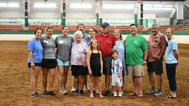 2026 State Show Dedication Recipient Wayne Moore and his family, friends, and Extension colleagues in the main arena of the Hunt Horse Complex