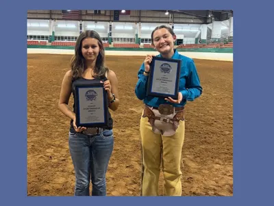 The senior and junior sportsmanship award winners posing with their plaques in the main arena of the Hunt Horse Complex.
