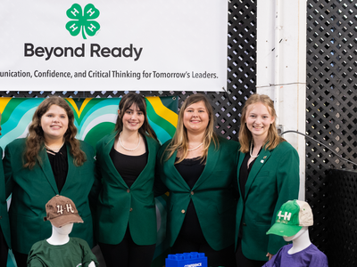State 4-H Officers, wearing their official green jacket attire, posed together for a group photo at the NC 4-H booth of the 2025 N.C. State Fair.