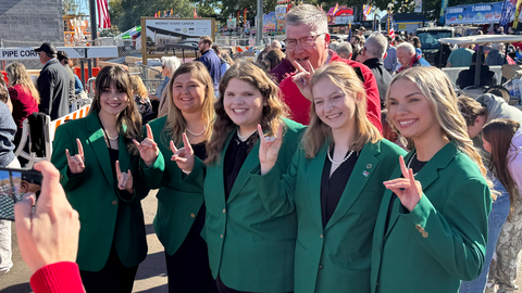 State 4-H Officers, wearing their official green jacket attire, posed together for a group photo with NC State's Dean College of Agriculture and Life Sciences at the 2025 N.C. State Fair.