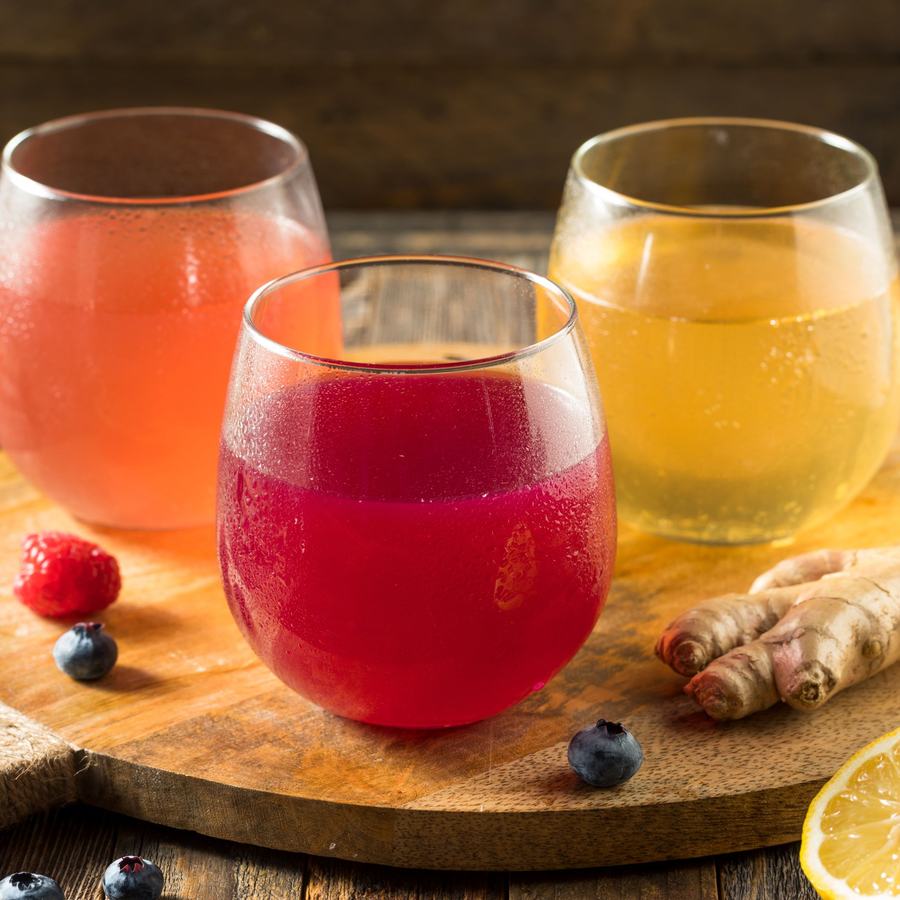 Cups of kombucha flavored with various fruits and juices