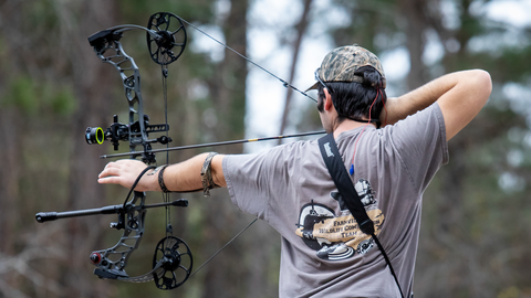 4-H member participating in an archery competition drawing a compound bow.