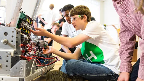 4-H members collaborate in a workshop, assembling and troubleshooting a robot.