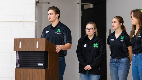 Youth officers addressing the participants of a district 4-H program.
