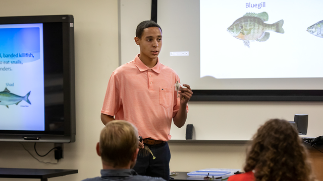 A 4-H'er giving a presentation on fishing.