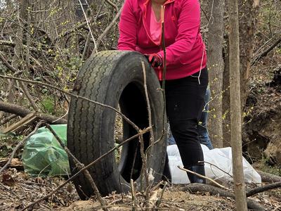 Lady removing a tire from the waterway
