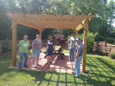 Onslow County Extension Master Gardeners smiling under the pergola in the children's garden.