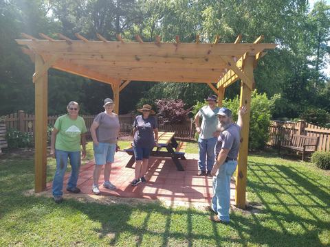 Onslow County Extension Master Gardeners smiling under the pergola in the children's garden.