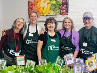 EMG volunteers of Durham County with healthy plants they grew smile and welcome the public to learn about sustainable gardening.