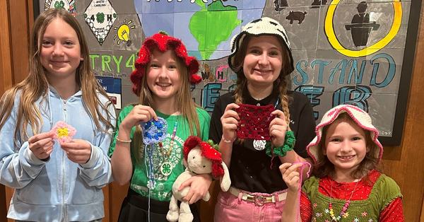 Yarn club members holding their projects