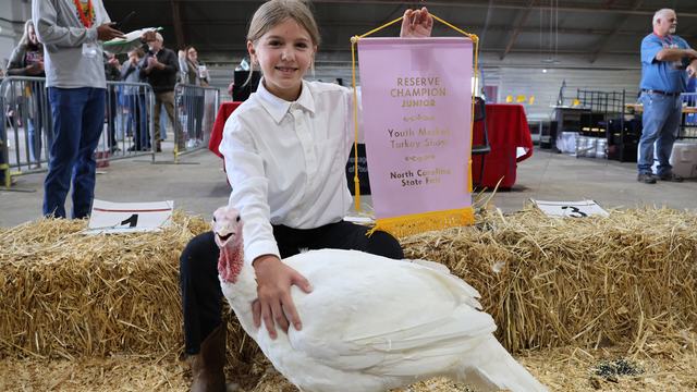 reserve champion junior 2025 winner with banner and her turkey in the showring